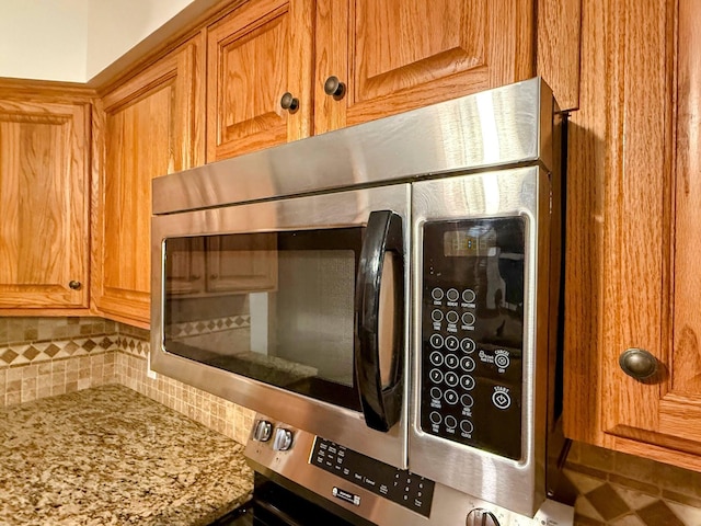 213 W Charles St, Republic, MO 65738 - kitchen view of tasteful backsplash, stainless steel microwave, and light stone countertops