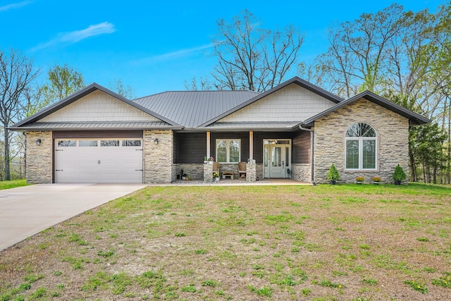 view of front of house featuring a front yard, a garage, covered porch, driveway, and stone siding