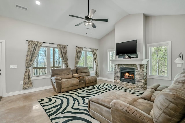 living room featuring visible vents, a ceiling fan, a stone fireplace, and baseboards