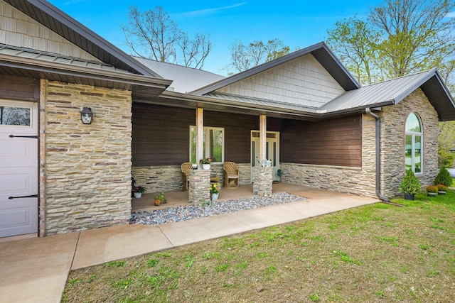 view of front facade featuring metal roof, a standing seam roof, stone siding, and covered porch