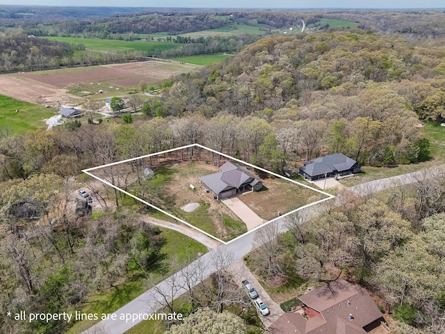 birds eye view of property featuring a forest view