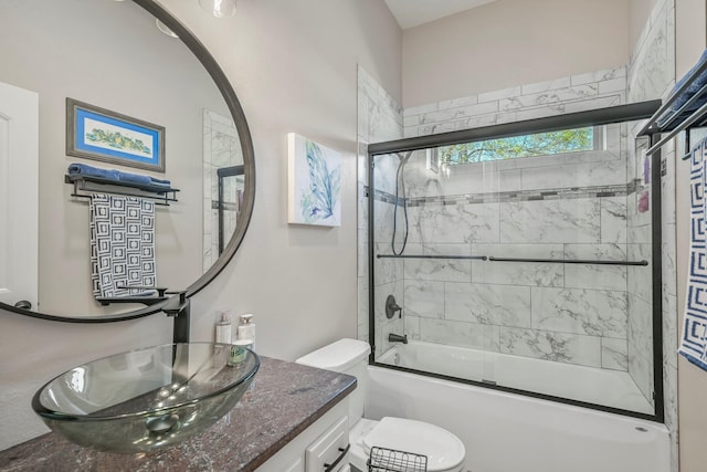bathroom featuring bath / shower combo with glass door, toilet, and vanity