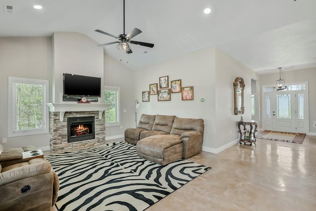 living room featuring finished concrete floors, a ceiling fan, a wealth of natural light, and baseboards