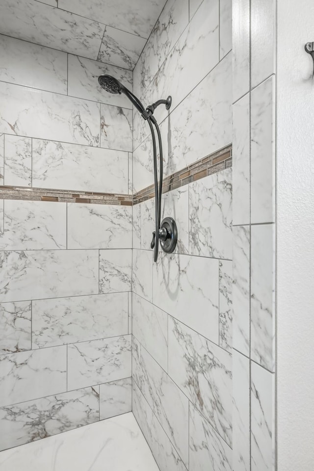 interior details with a tile shower