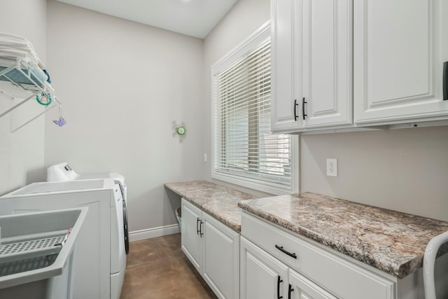 laundry area with baseboards, cabinet space, and washing machine and clothes dryer