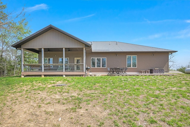 rear view of property featuring metal roof, a lawn, a ceiling fan, and a deck