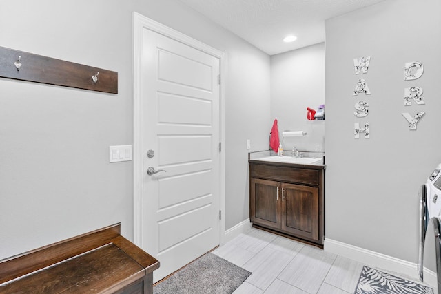 interior space with recessed lighting, a sink, and baseboards