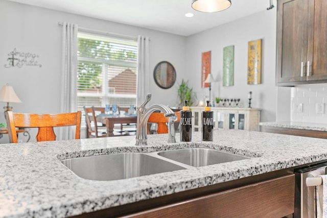 kitchen with recessed lighting, a sink, and light stone counters