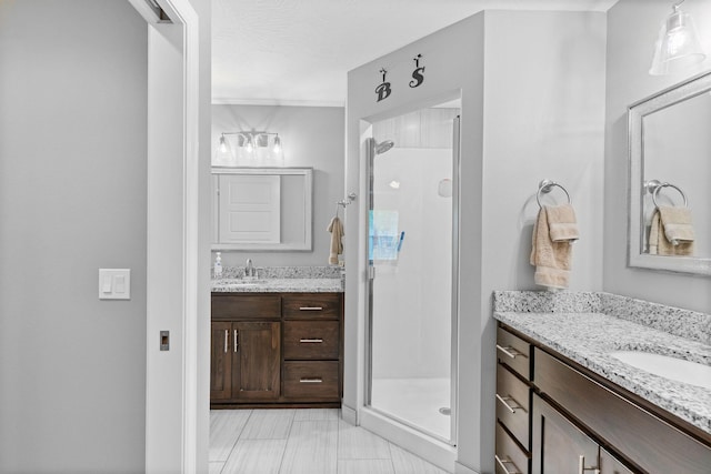 full bathroom featuring a stall shower, two vanities, and a sink