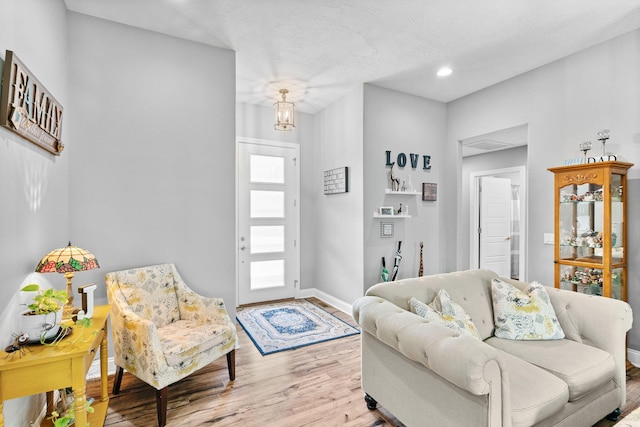 living area with baseboards, recessed lighting, and wood finished floors