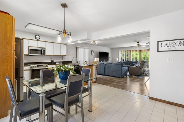 dining area featuring baseboards, light tile patterned floors, and a ceiling fan
