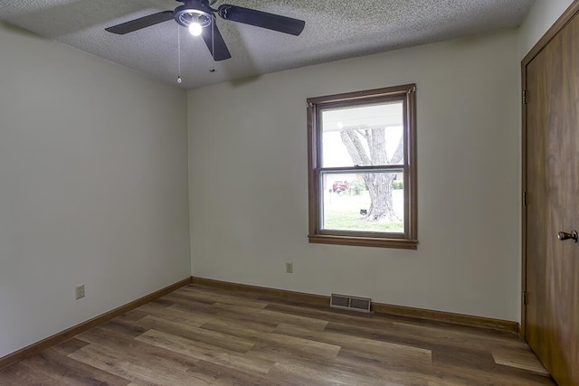 unfurnished bedroom featuring baseboards, visible vents, wood finished floors, and a textured ceiling