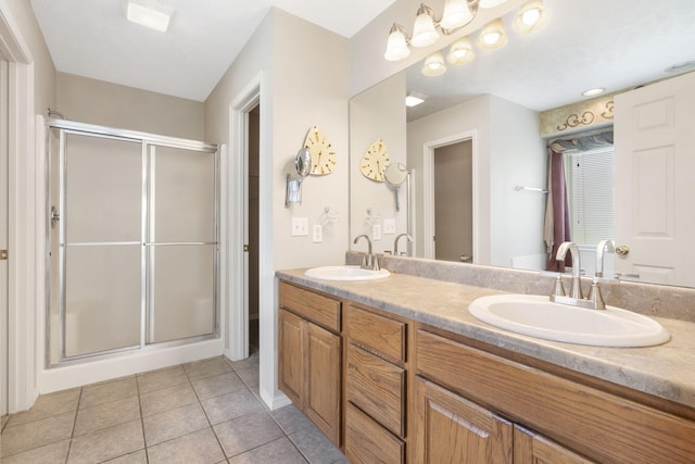 full bath with a stall shower, tile patterned flooring, and a sink