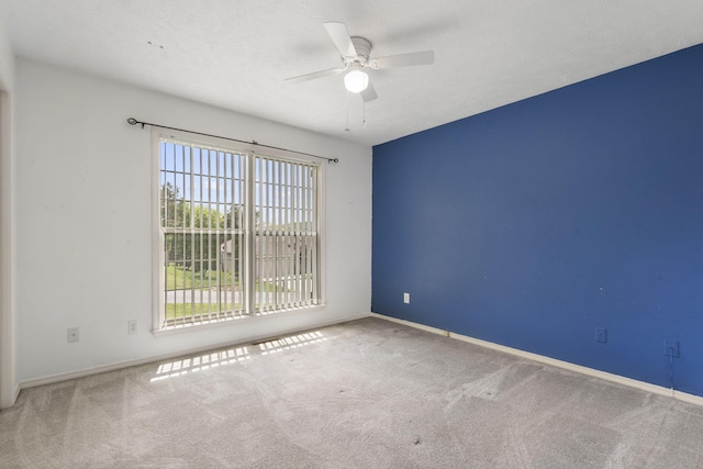 unfurnished room featuring a ceiling fan, carpet floors, and baseboards