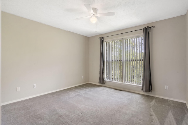 unfurnished room with carpet flooring, ceiling fan, and baseboards