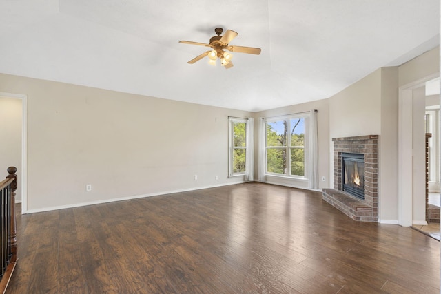 unfurnished living room with a fireplace, dark wood-type flooring, a ceiling fan, baseboards, and lofted ceiling