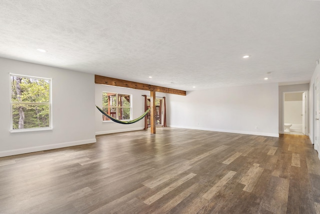 unfurnished living room featuring recessed lighting, a textured ceiling, wood finished floors, and baseboards
