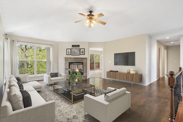 living area with ceiling fan, baseboards, recessed lighting, a brick fireplace, and wood finished floors