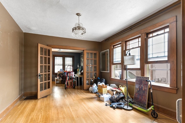 937 S Fremont Ave, Springfield, MO 65804 - miscellaneous room with a healthy amount of sunlight, wood finished floors, an inviting chandelier, and french doors