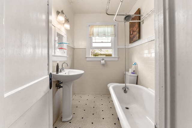 937 S Fremont Ave, Springfield, MO 65804 - bathroom with tile walls, a wainscoted wall, tile patterned flooring, and a bathtub