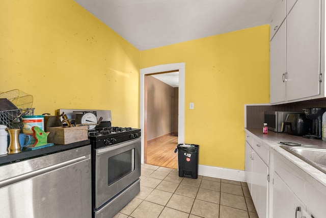 937 S Fremont Ave, Springfield, MO 65804 - kitchen featuring light tile patterned floors, baseboards, white cabinets, and stainless steel range with gas cooktop