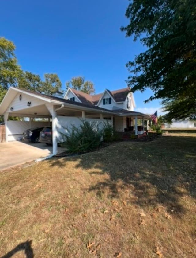 view of property exterior featuring a lawn, a carport, driveway, and a porch