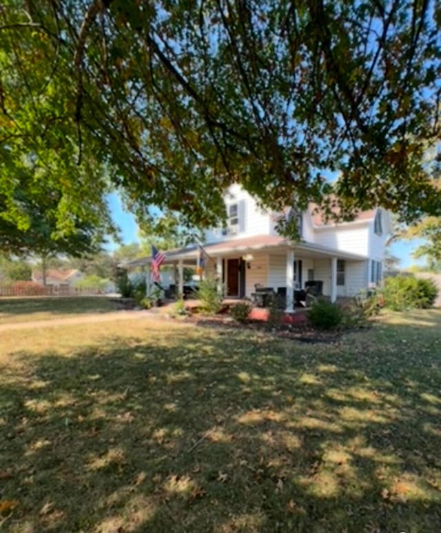 view of front of property featuring covered porch and a front yard