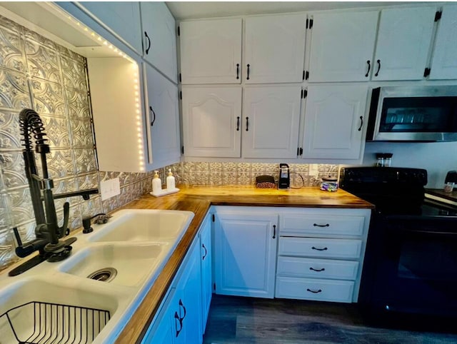 kitchen featuring wood counters, stainless steel microwave, white cabinets, dark wood-style floors, and black / electric stove