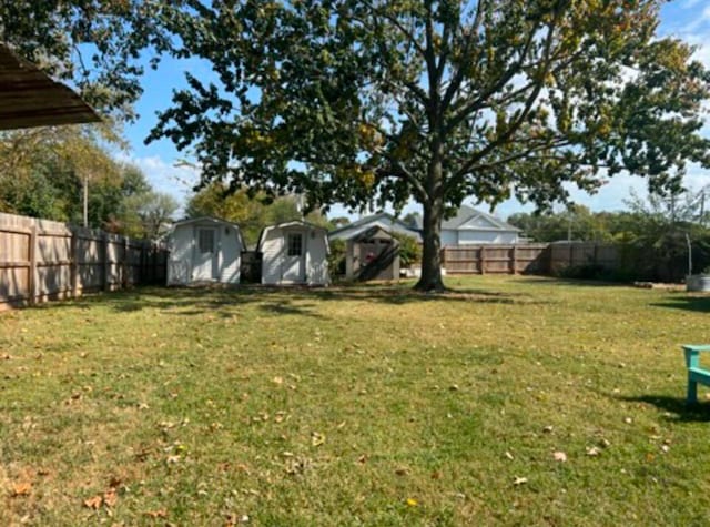 view of yard featuring an outdoor structure, a storage shed, and a fenced backyard
