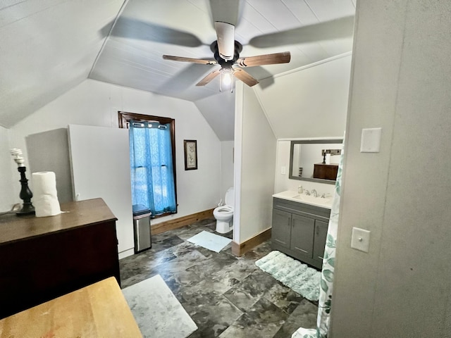 bathroom featuring vaulted ceiling, ceiling fan, toilet, vanity, and baseboards
