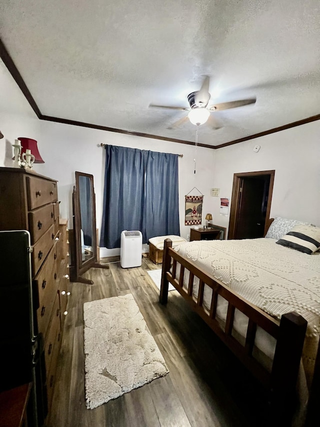 bedroom featuring wood finished floors, ceiling fan, a textured ceiling, and crown molding