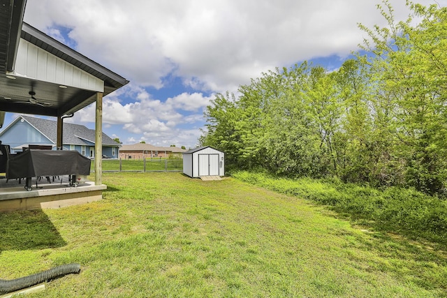 2460 S Durango Dr, Bolivar, MO 65613 - view of yard featuring an outbuilding, a ceiling fan, a storage unit, and fence
