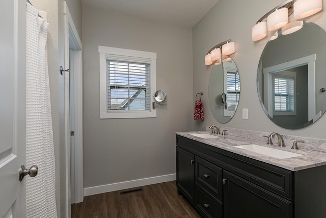 2460 S Durango Dr, Bolivar, MO 65613 - bathroom featuring double vanity, wood finished floors, visible vents, and a sink