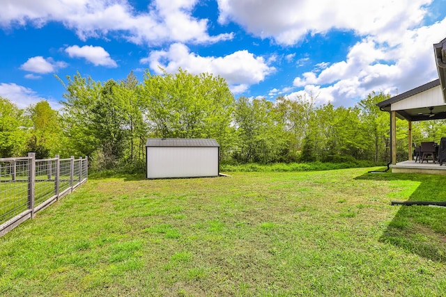 2460 S Durango Dr, Bolivar, MO 65613 - view of yard with an outbuilding, a storage shed, ceiling fan, and fence