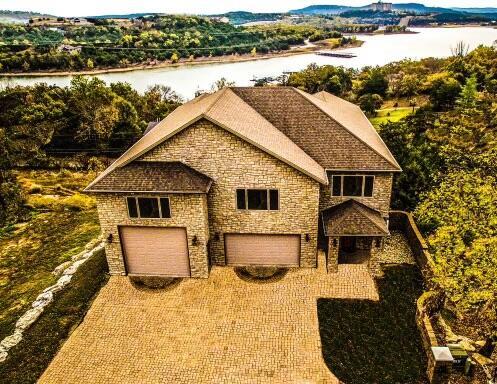 48 King Cir, Branson, MO 65616 - exterior space featuring a garage, decorative driveway, a water view, and stone siding