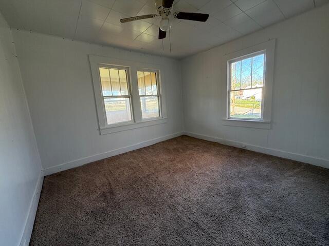 empty room featuring baseboards, a ceiling fan, and carpet floors