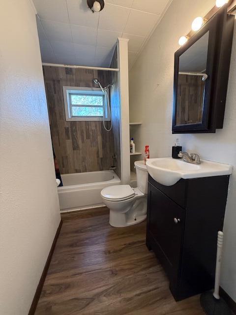 full bathroom with wood finished floors, toilet, tub / shower combination, and vanity