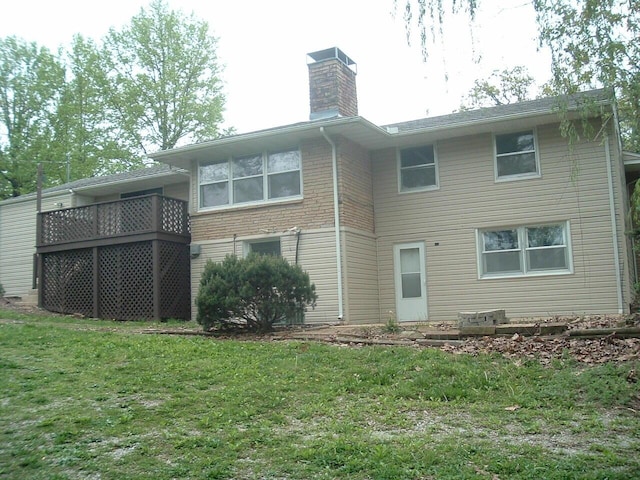 back of property featuring a chimney and a lawn