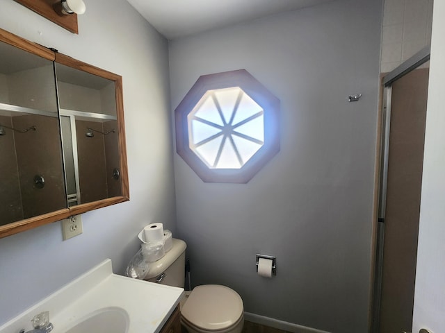 bathroom with a shower with shower door, vanity, and toilet