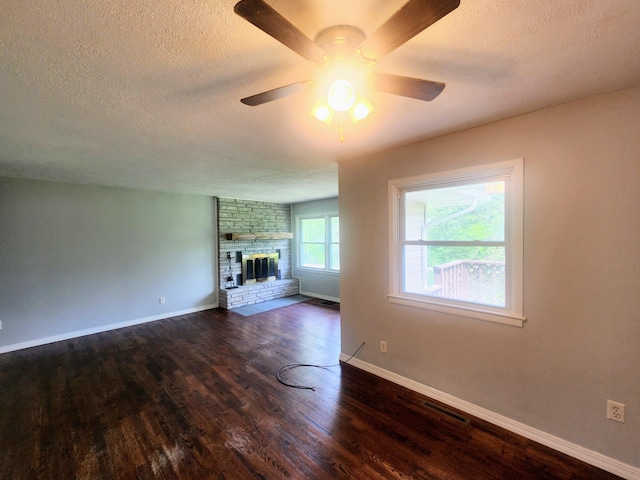 unfurnished living room with a textured ceiling, visible vents, wood finished floors, and a ceiling fan