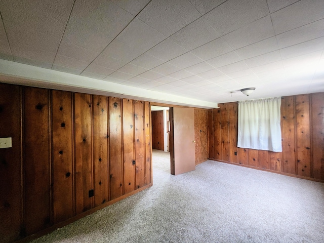 below grade area with wooden walls, carpet, and baseboards