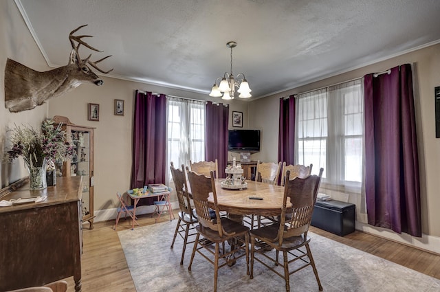 110 N Connor Ave, Joplin, MO 64801 - dining area with crown molding, light wood-style flooring, a chandelier, and baseboards