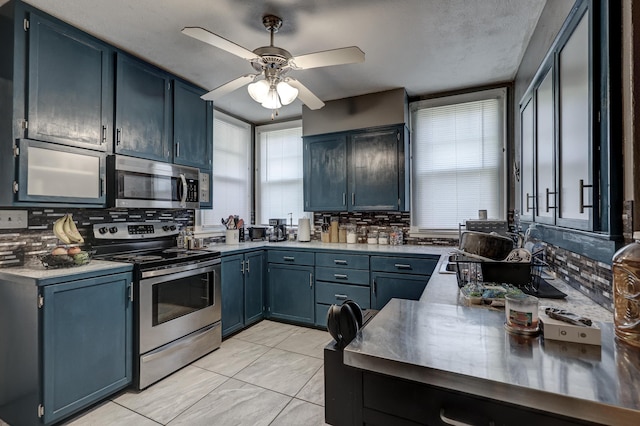 110 N Connor Ave, Joplin, MO 64801 - kitchen with decorative backsplash, appliances with stainless steel finishes, light countertops, blue cabinetry, and a ceiling fan