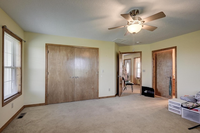 bedroom featuring light colored carpet, visible vents, and multiple windows