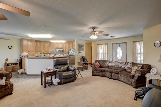 living area with a textured ceiling, a ceiling fan, and light carpet