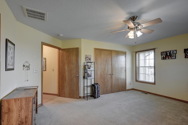 bedroom with light colored carpet, visible vents, baseboards, a closet, and a ceiling fan