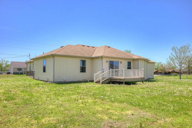 back of property featuring fence, a deck, and a yard