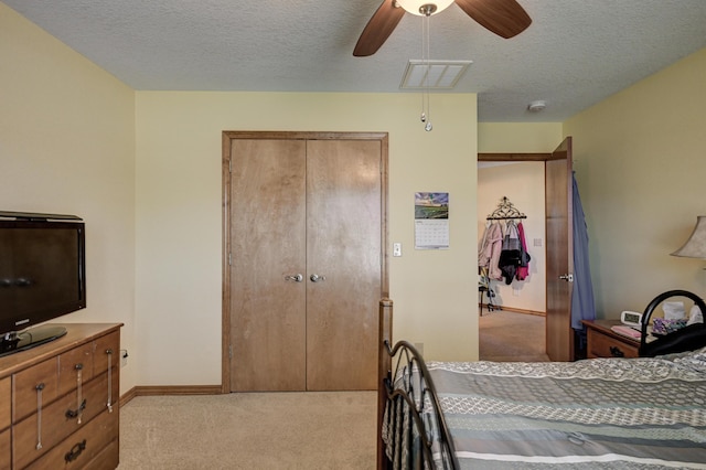 bedroom with a textured ceiling, visible vents, carpet flooring, and baseboards