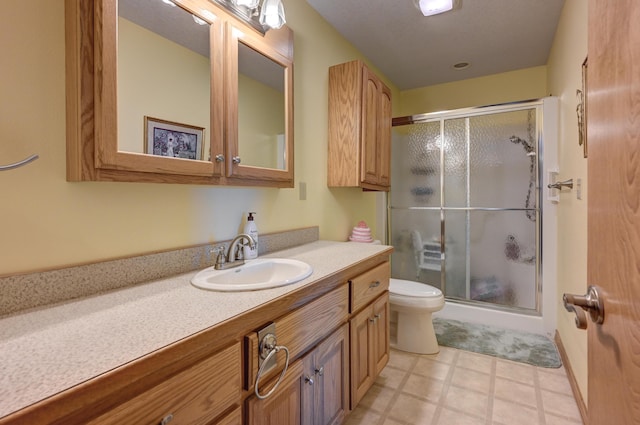 full bathroom featuring toilet, tile patterned floors, a shower stall, and vanity
