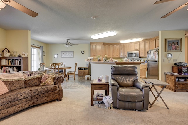 living room featuring light carpet, ceiling fan, and a textured ceiling